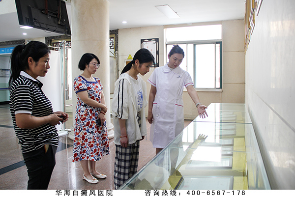 工作人员引领樊亚群母女参观医院的科研成就.jpg